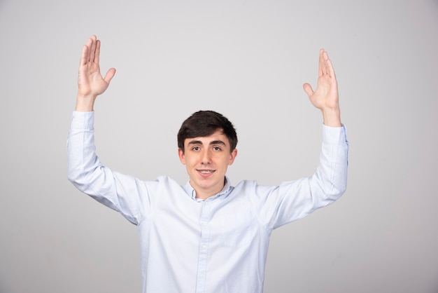 Photo de portrait d'un homme souriant debout et montrant la taille avec les mains