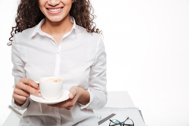 Photo recadrée de femme d'affaires africaine heureuse, boire du café