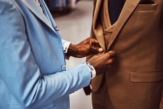 Photo recadrée. Homme afro-américain élégamment habillé travaillant dans un magasin de vêtements pour hommes classique.