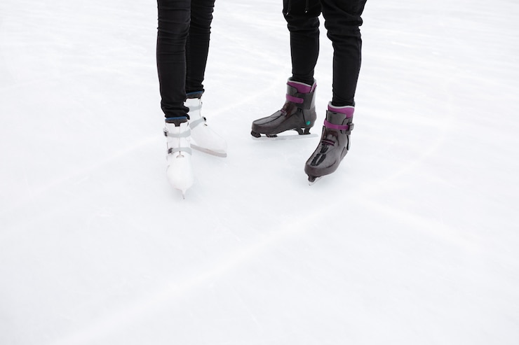 Photo gratuit photo recadrée de jeune couple d'amoureux patinant à la patinoire