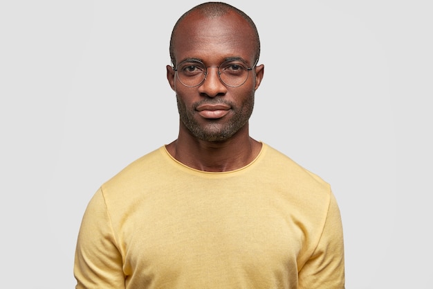 Photo gratuite photo de studio d'homme afro-américain confiant sérieux dans des lunettes