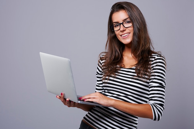 Photo de Studio de jeune brune avec ordinateur portable