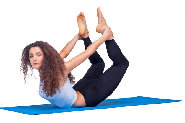 Photo de Studio d'une jeune femme en forme faisant des exercices de yoga.