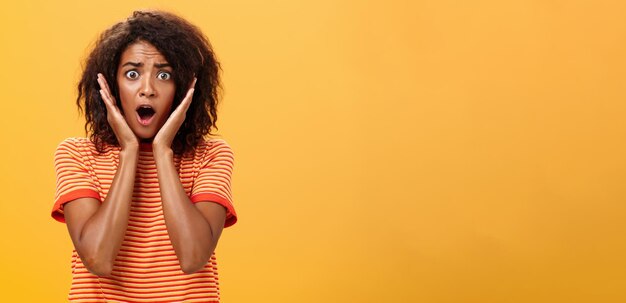 Une photo de taille d'une femme afro-américaine en panique avec une coiffure afro à la mode.