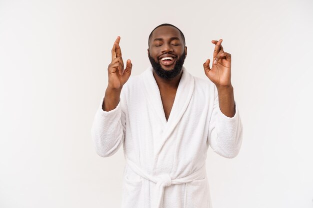 Photo de tête d'un homme afro-américain croisant les doigts souhaitant et priant pour un miracle en espérant le meilleur isolé contre le mur de l'espace de copie blanche Expressions et sentiments humains positifs