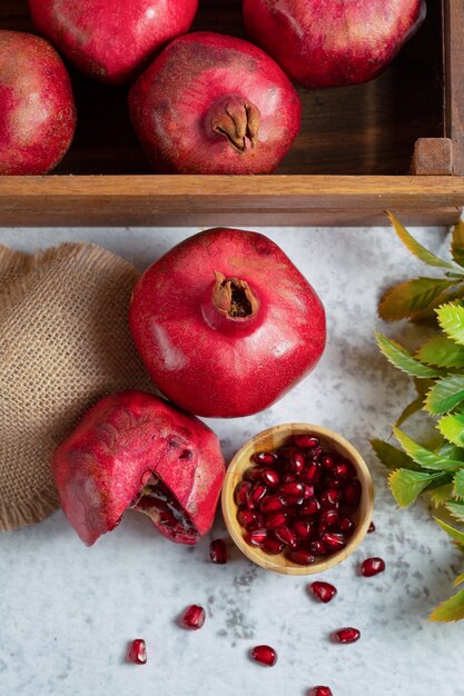 Photo verticale d'une boîte de fruits et de grenades fraîches.