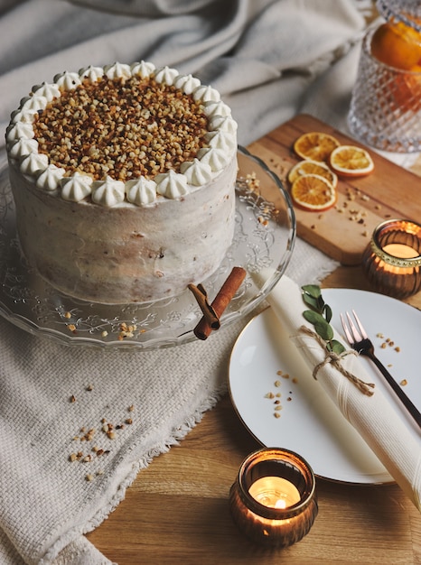 Photo verticale d'un délicieux gâteau de Noël blanc avec des noix et mandarine