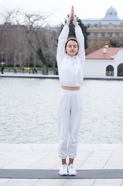 Photo verticale d'une jeune femme levant les mains et faisant ses exercices Photo de haute qualité