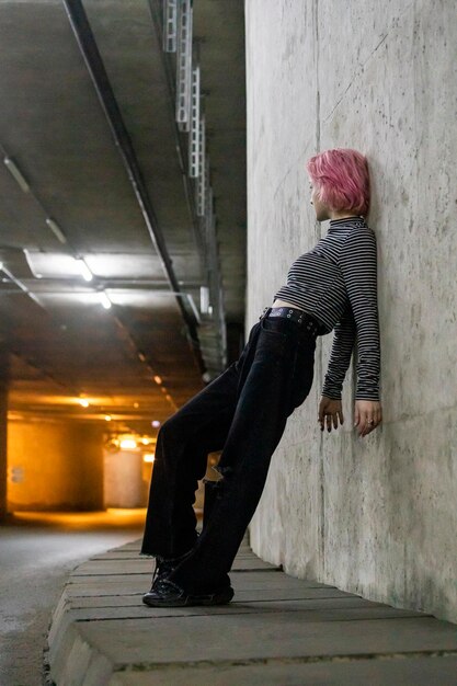 Photo verticale de jeune femme s'appuyant sur le mur au tunnel