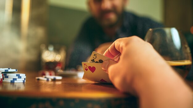 Photo vue de côté d'amis assis à une table en bois.