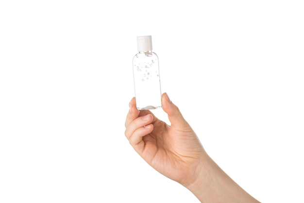 Photo de vue en gros plan recadrée d'une main féminine montrant une petite petite bouteille transparente avec un fond blanc isolé de liquide antibactérien