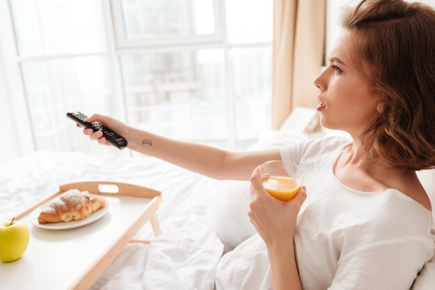 Photo vue latérale d'une jeune femme sérieuse regarder la télévision