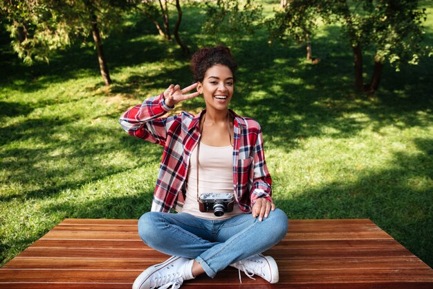 Photographe femme assise à l'extérieur dans le parc.