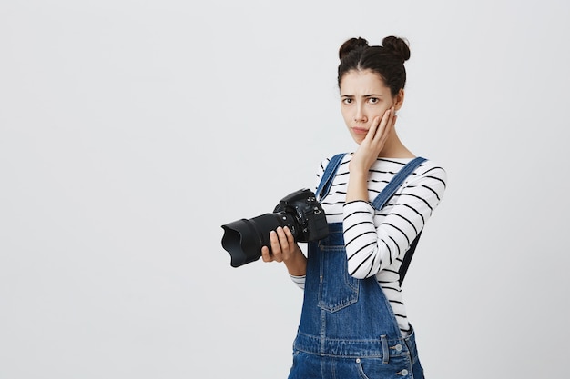 Photographe de fille inquiète se sentant nerveux. Femme tenant la caméra et se sentir bouleversé