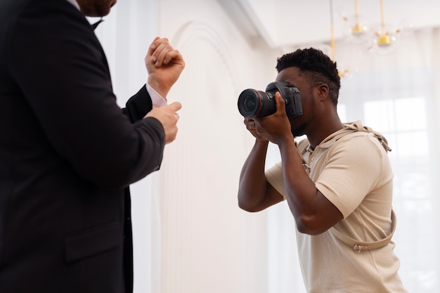 Photo gratuite photographe et marié de vue de côté