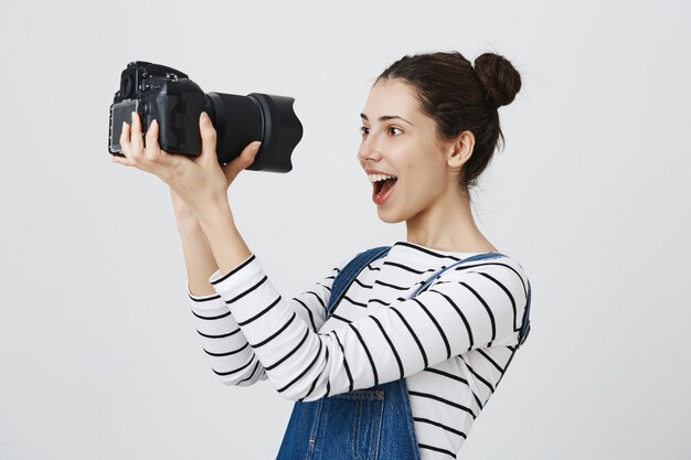 Une photographe mignonne et excitée reçoit un nouvel appareil photo professionnel