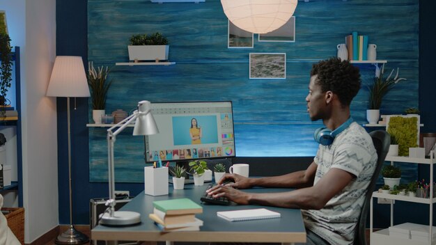 Photographe retouchant des images sur ordinateur avec l'application d'édition