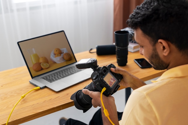 Photo gratuite photographe spécialisé en vue latérale travaillant en studio