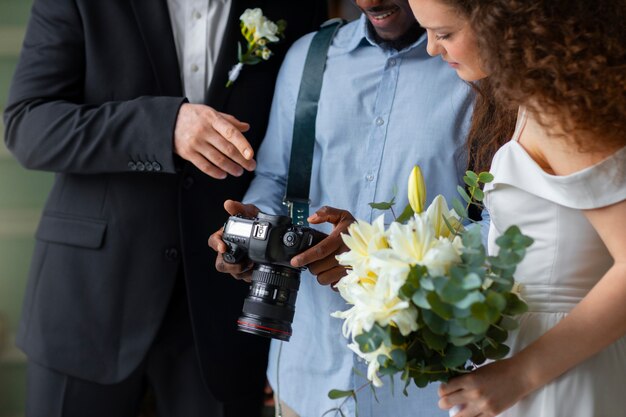 Photographe de vue de côté et couple marié