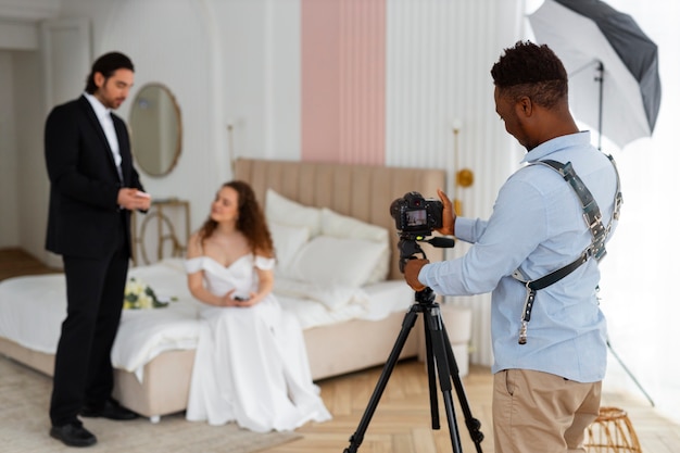 Photo gratuite photographe de vue de côté et couple marié