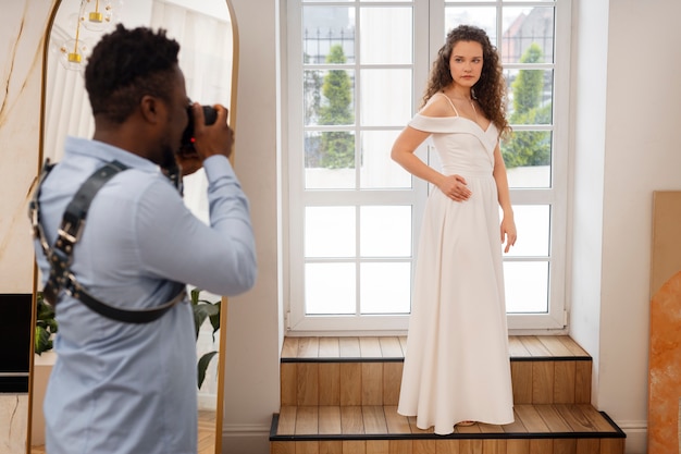 Photographe de vue latérale prenant des photos de la mariée