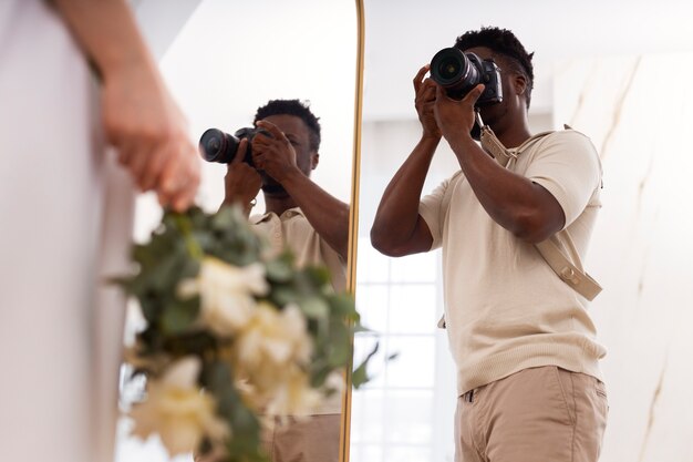 Photographe de vue latérale prenant des photos de la mariée