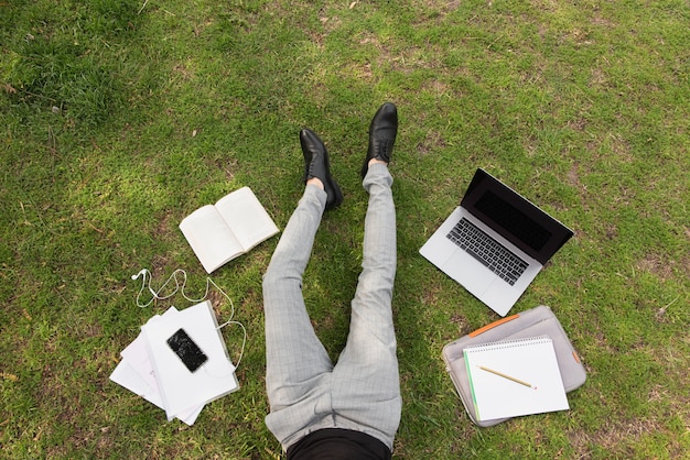 Photographie artistique d'un étudiant avec ordinateur portable et notes