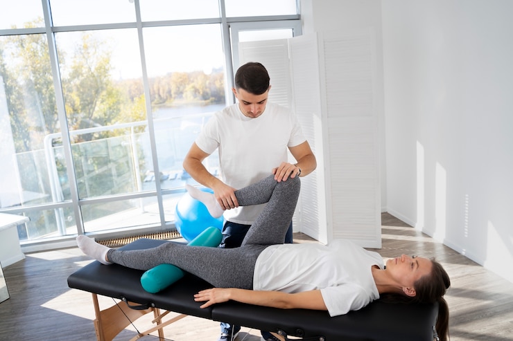 Photo gratuit physiothérapeute aidant le patient à tirer