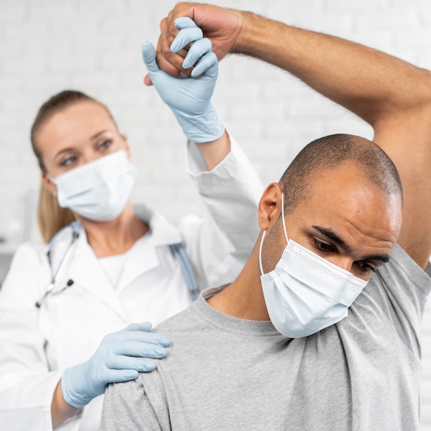 Photo gratuite physiothérapeute femelle contrôle la mobilité de l'homme