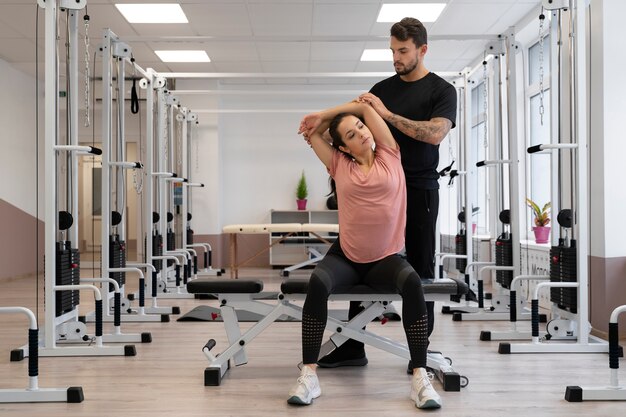 Physiothérapeute plein coup aidant la femme