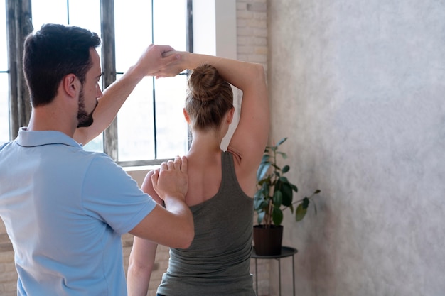 Photo gratuite physiothérapeute vérifiant le tir moyen du patient