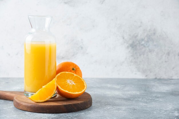 Pichet en verre de jus avec tranche de fruit orange.