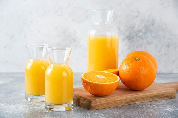 Pichets en verre de jus avec tranche de fruit orange.