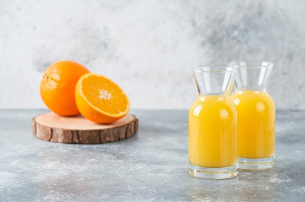 Pichets en verre de jus avec tranche de fruit orange.