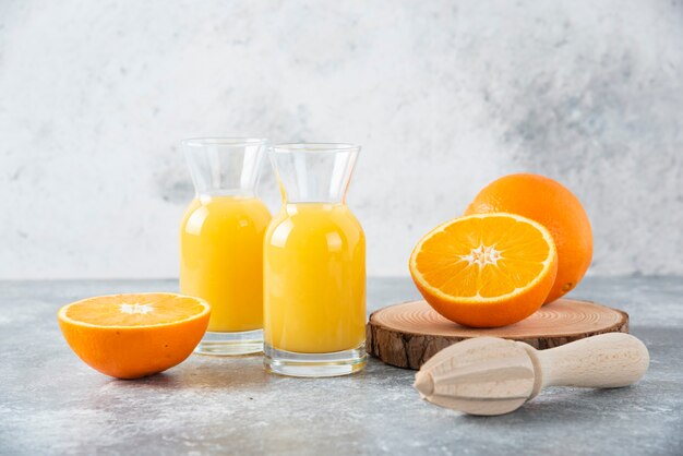 Pichets en verre de jus avec tranche de fruit orange.