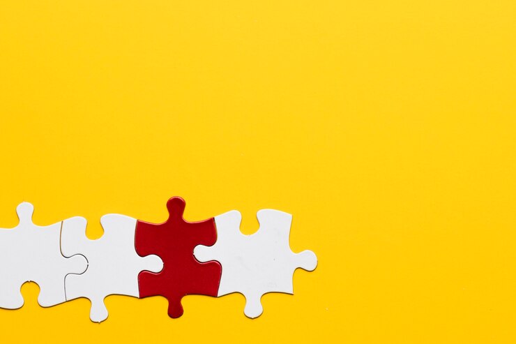Photo gratuit pièce de puzzle rouge et blanche sur fond d&#39;espace de copie jaune