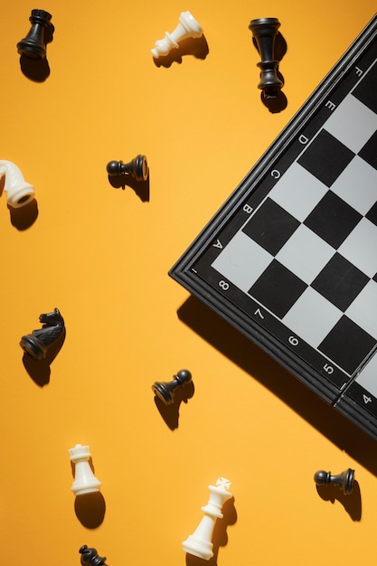 Photo gratuite pièces d'échecs et échiquier sur fond jaune