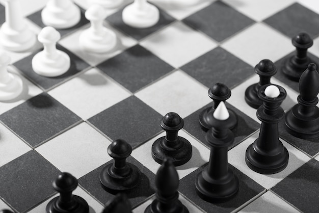 Photo gratuite pièces d'échecs monochromes avec plateau de jeu