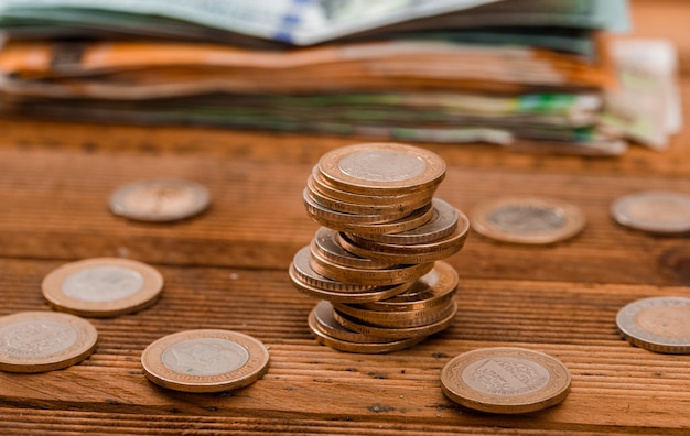 pièces de monnaie, billets de banque sur table en bois.