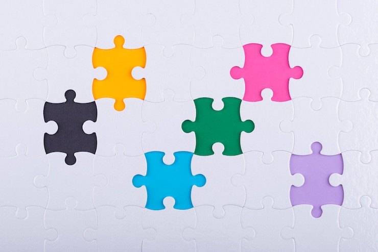 Photo gratuit pièces de puzzle blanches vue de dessus et fond coloré