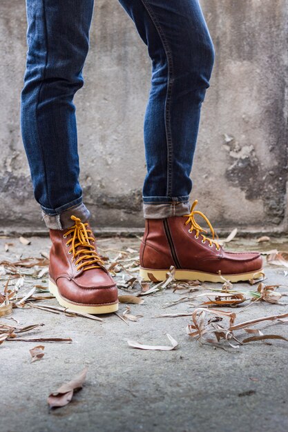 Pied masculin avec des chaussures en cuir marron et un jean