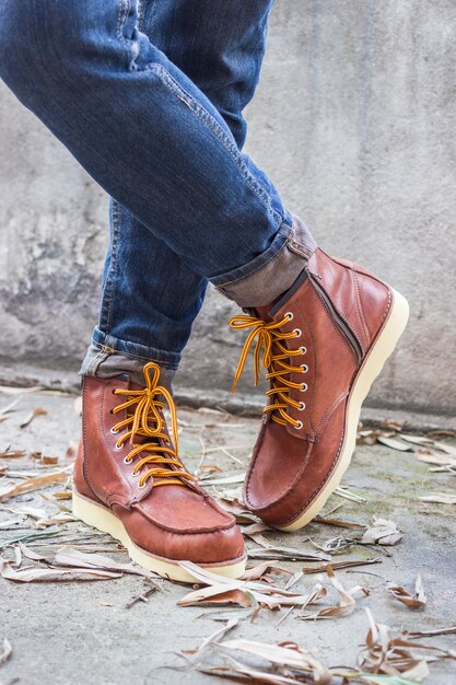 Pied masculin avec des chaussures en cuir marron et un jean