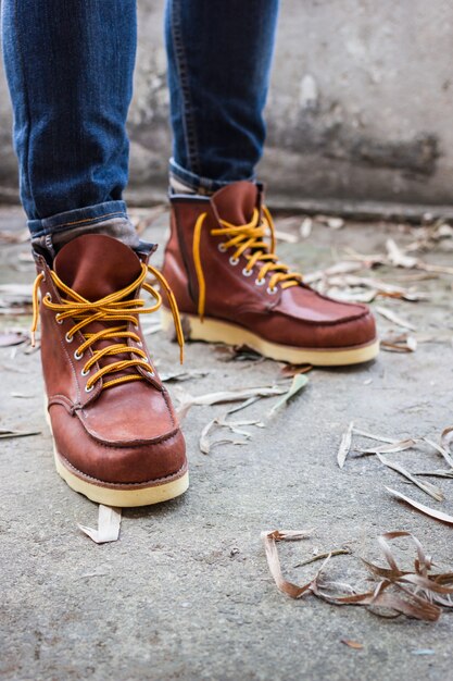 Pied masculin avec des chaussures en cuir marron et un jean