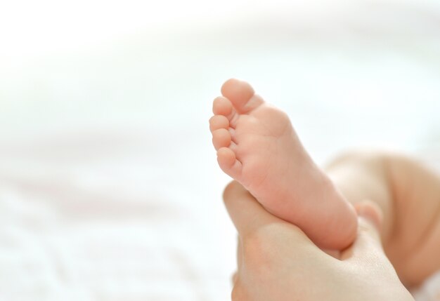 Pieds de bébé en main mère.