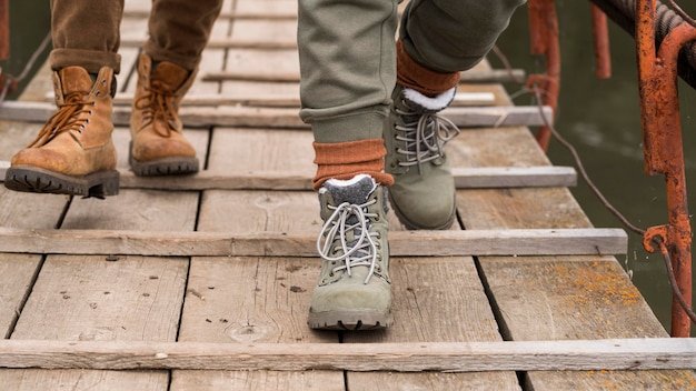 Photo gratuite pieds de couple gros plan sur pont en bois