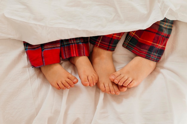 Les pieds des enfants au lit le jour de Noël