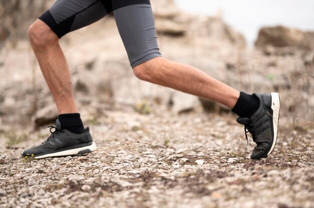 Pieds de l'homme gros plan sur sentier dans la nature