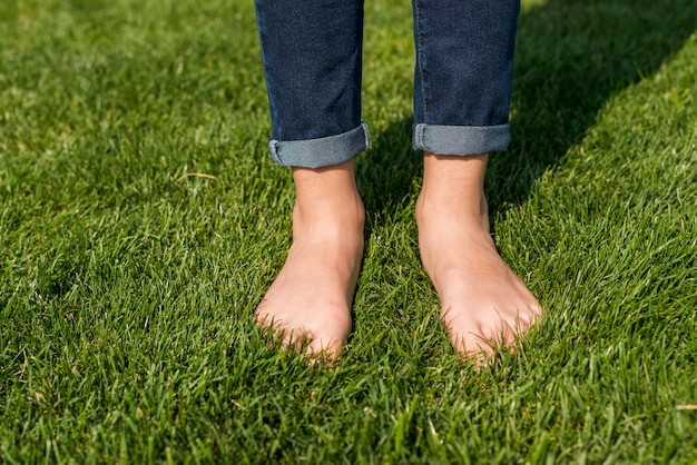 Pieds nus petite fille debout sur l'herbe close-up