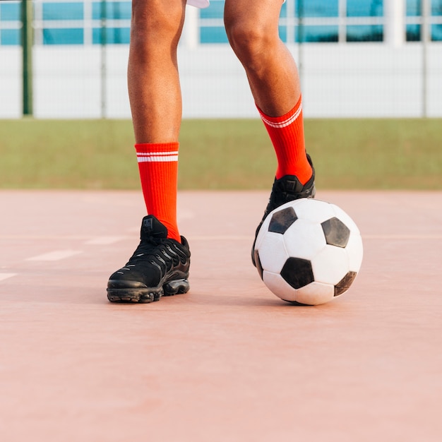 Photo gratuite pieds de sportif jouant au football au stade