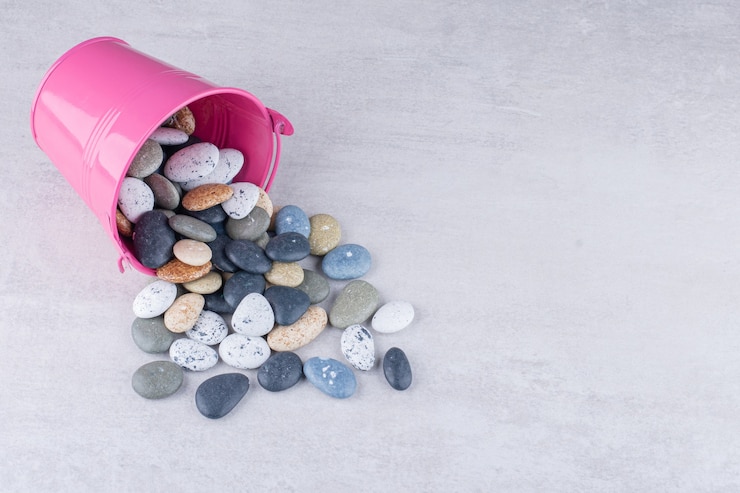 Photo gratuit pierres de plage multicolores pour l'artisanat sur une surface en béton